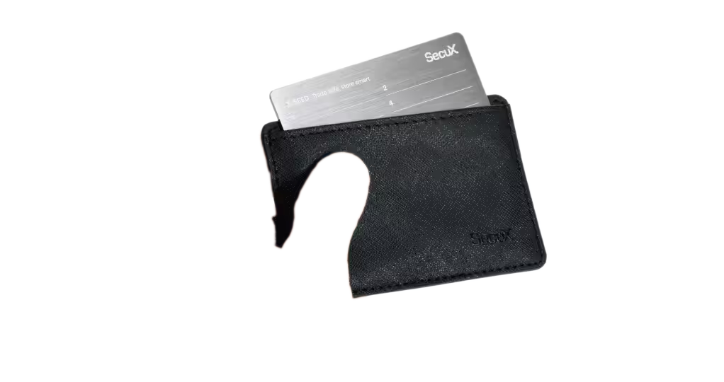 Hand holding the SecuX X-SEED protective case with a stainless steel seed plate inside