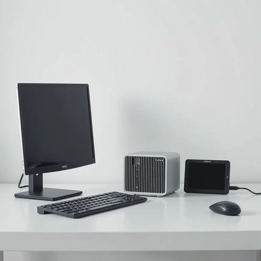 Cube-style Intel N100 mini PC on a desk beside a keyboard and small monitor