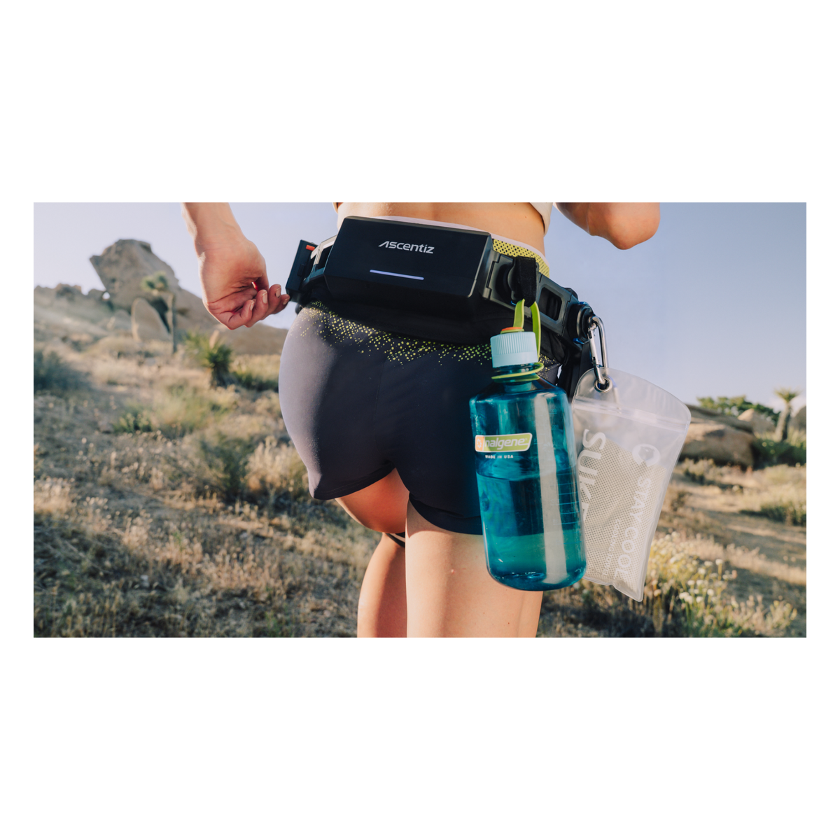 Runner wearing an Ascentiz Exo-Belt with the Quick-Link mount carrying a water bottle via carabiner on the trail