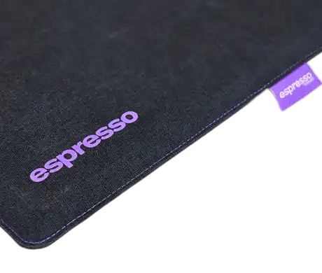 Black mouse pad with purple "espresso" branding and stitched edges.