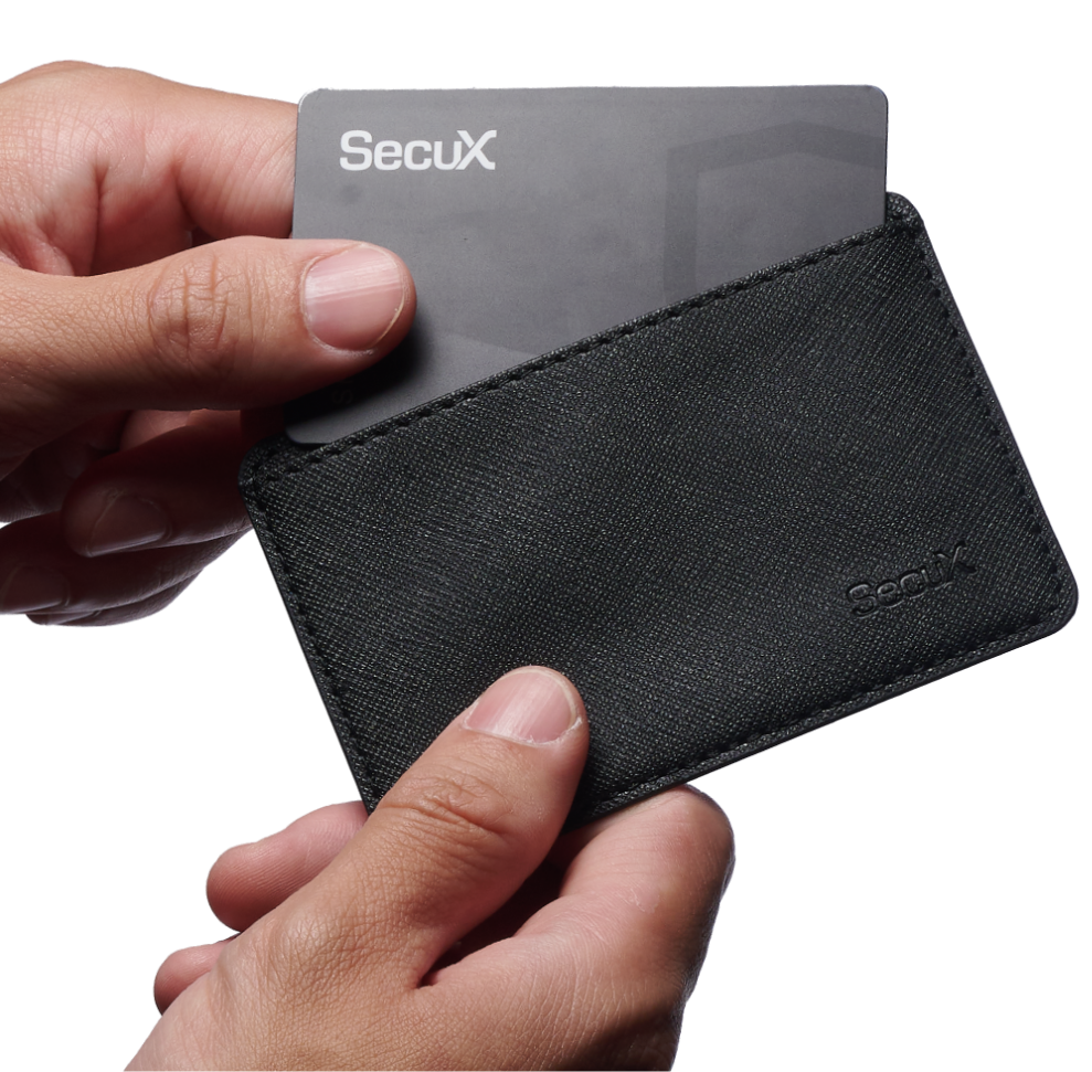 Hands sliding the SecuX Shield BIO card into its black protective case