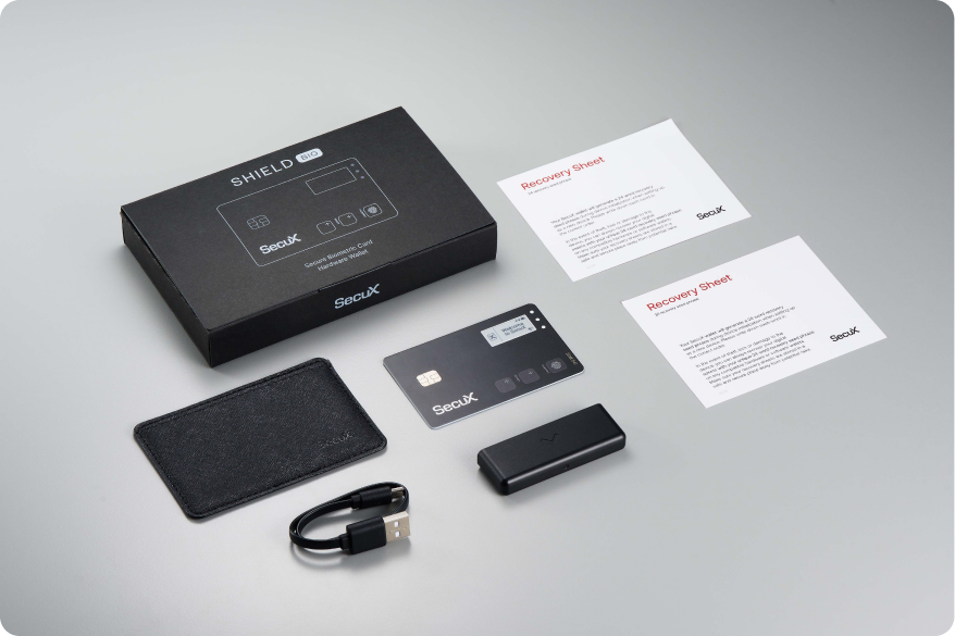SecuX Shield BIO box contents: card, charging dock, USB cable, protective case and two recovery sheets