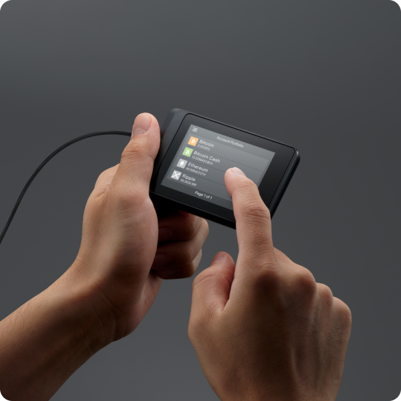 SecuX W10 held in two hands while a finger taps the touchscreen account list