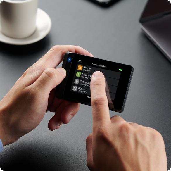 SecuX W20 held in two hands while a finger taps the touchscreen account list