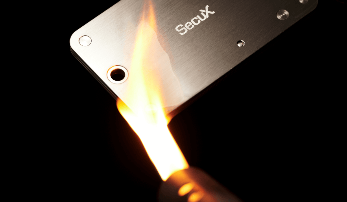 SecuX X-SEED PRO stainless steel seed storage held in a flame